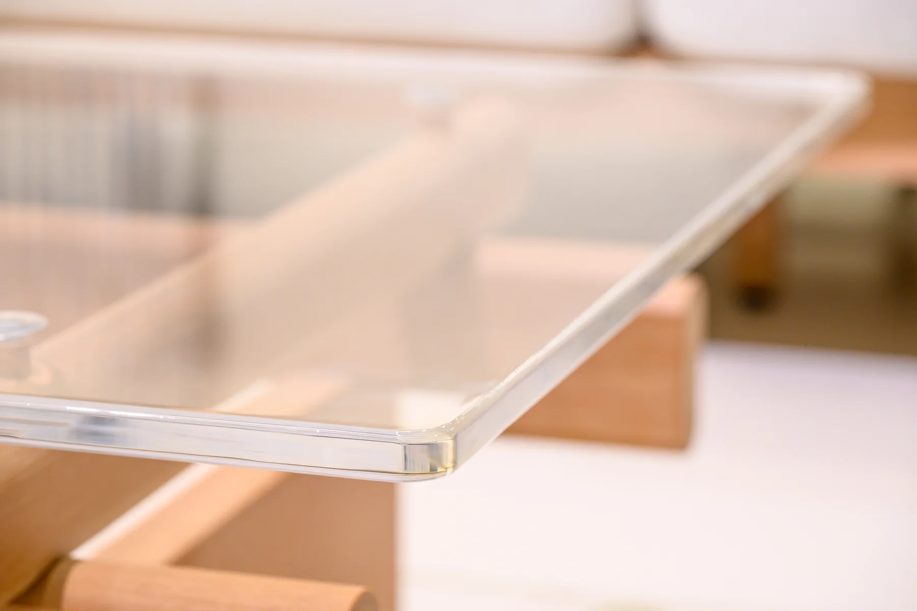 Close view of a transparent tabletop corner above its supporting frame