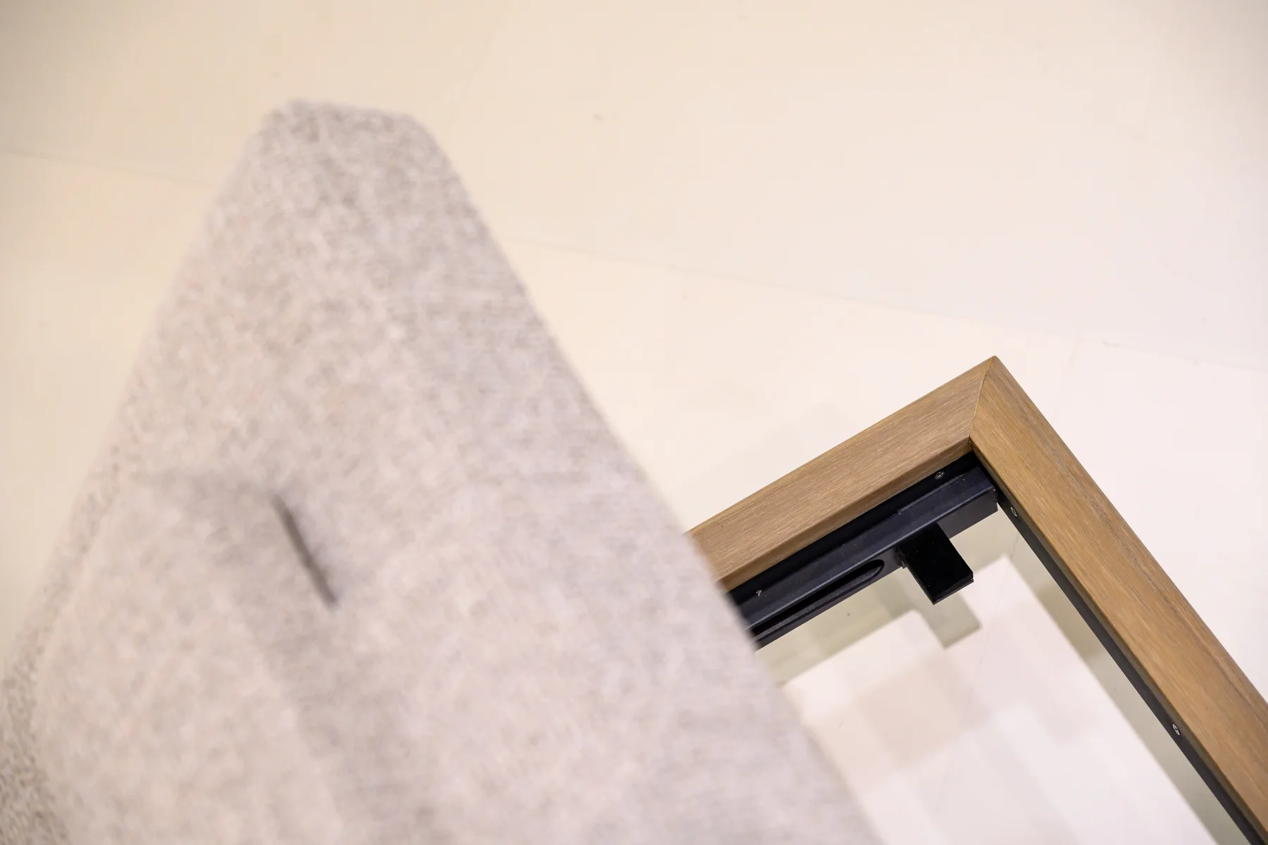 Cushion beside an exposed furniture-frame corner and dark support
