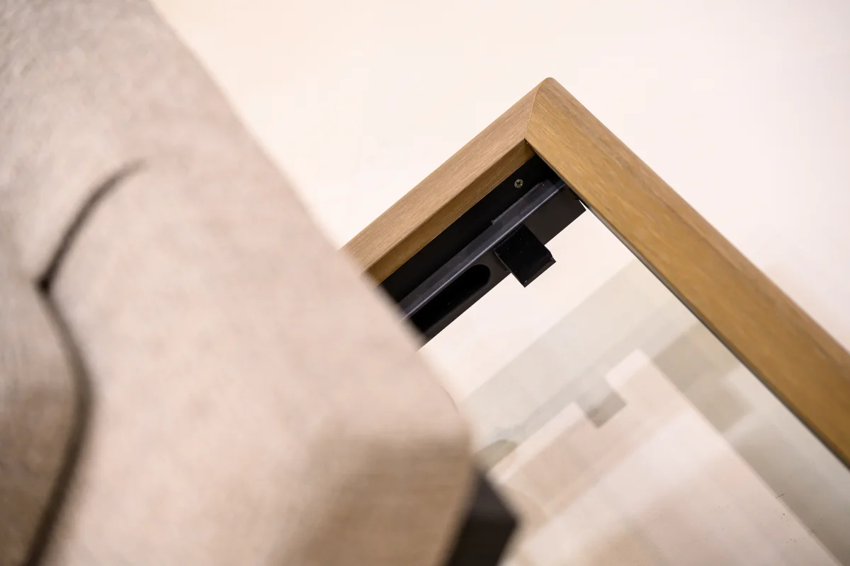 Exposed dark support beneath a lounger cushion beside the corner of its outer frame