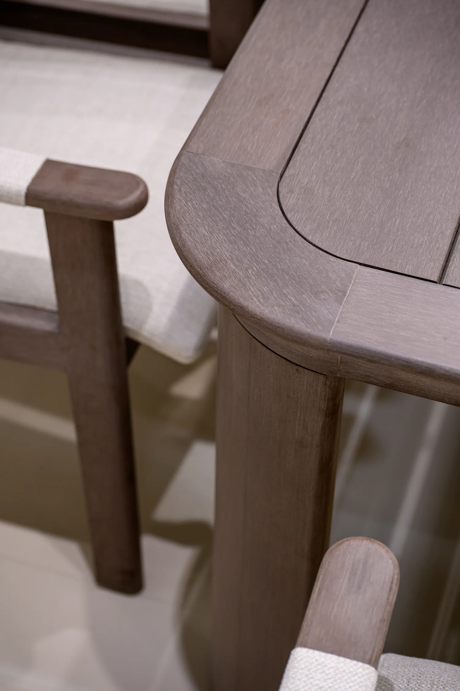 Rounded table edge with an inset top beside an upholstered chair