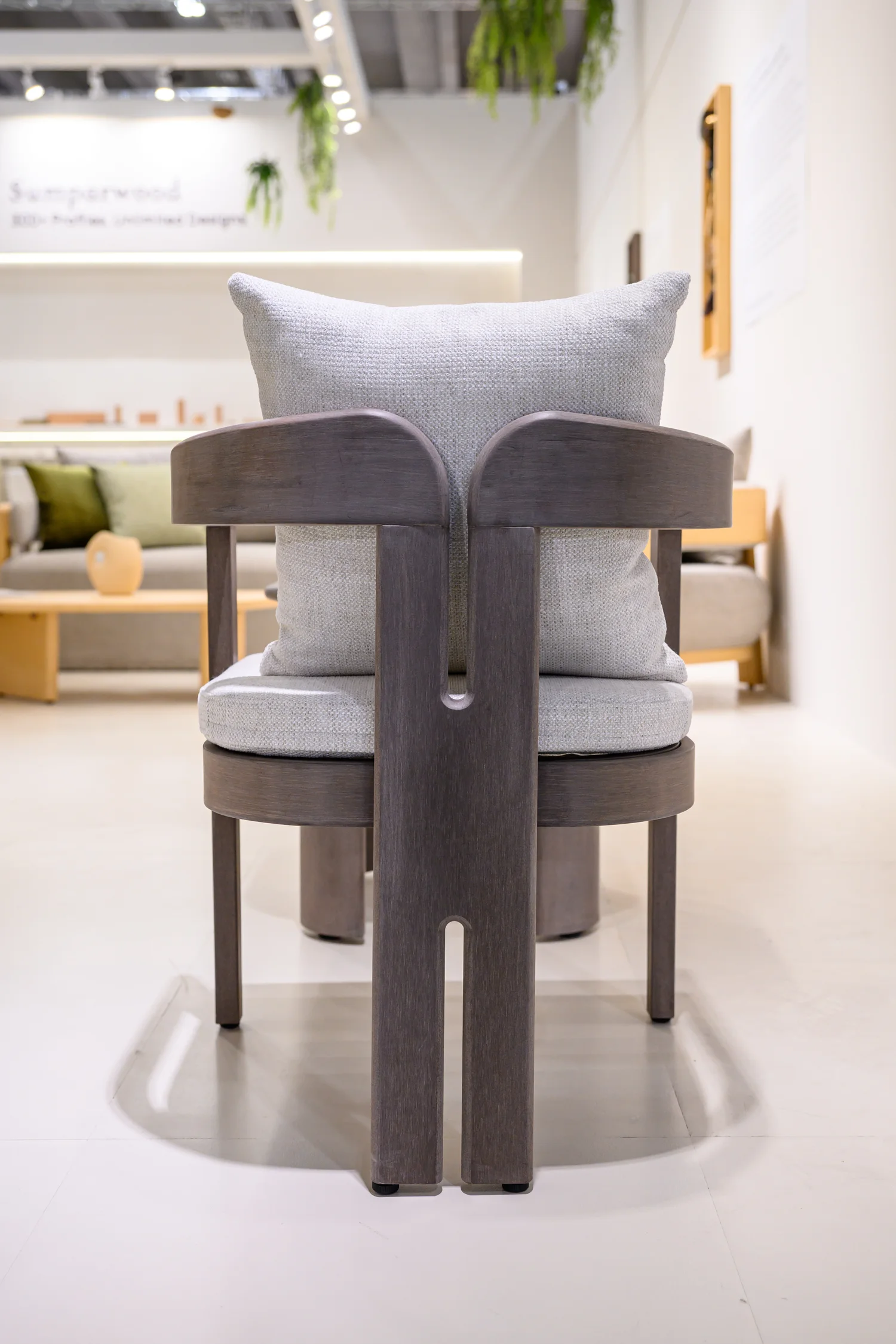 Rear view of a dark chair with two broad back uprights and upholstered cushions