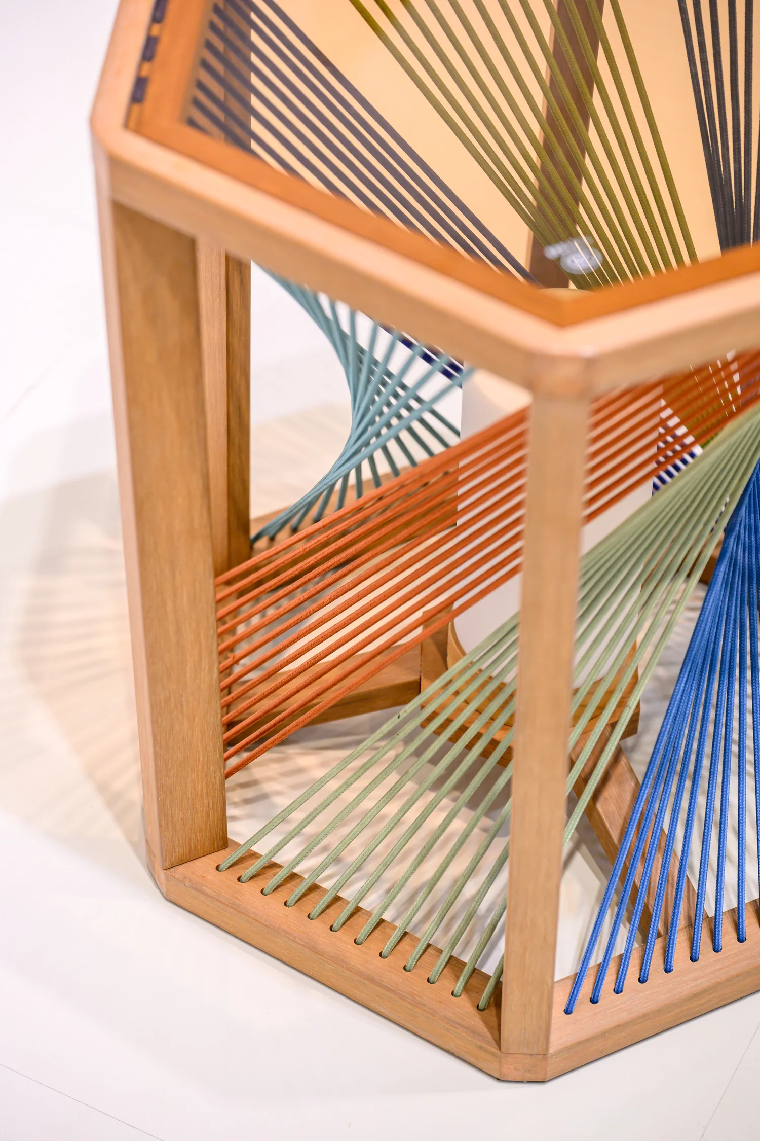 Pale furniture frame beside closely spaced multicoloured cords