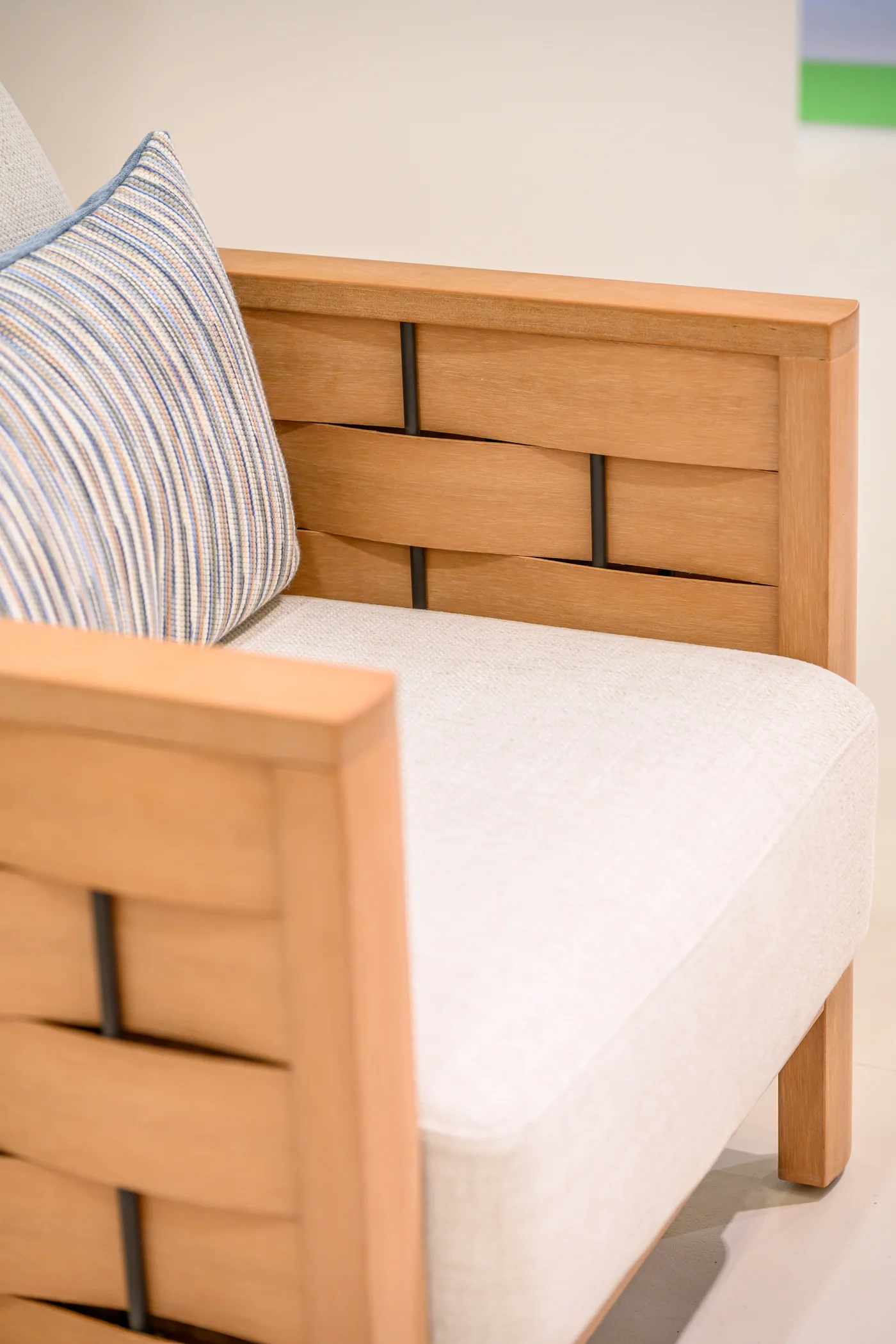 Pale cushion and striped pillow beside a broad interlaced chair frame