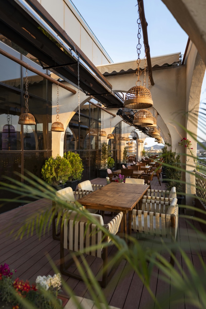 Outdoor hospitality terrace with tables and seating at golden hour.