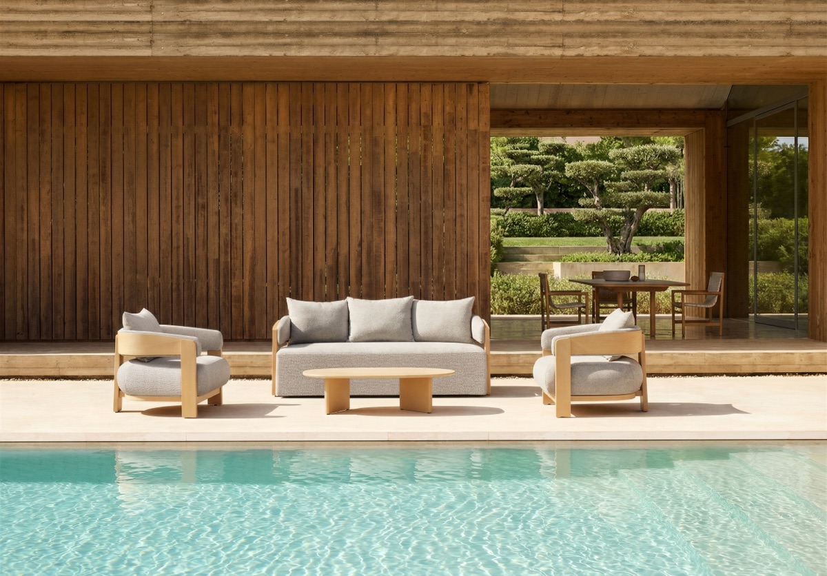 Outdoor sofa and lounge chairs arranged beside a swimming pool under partial shelter.