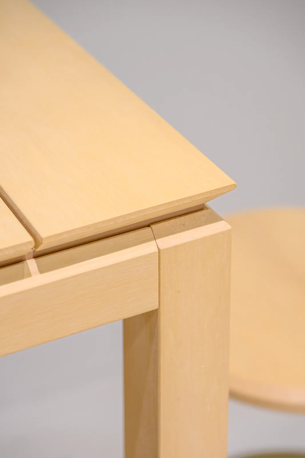 Close view of a pale tabletop corner and supporting frame