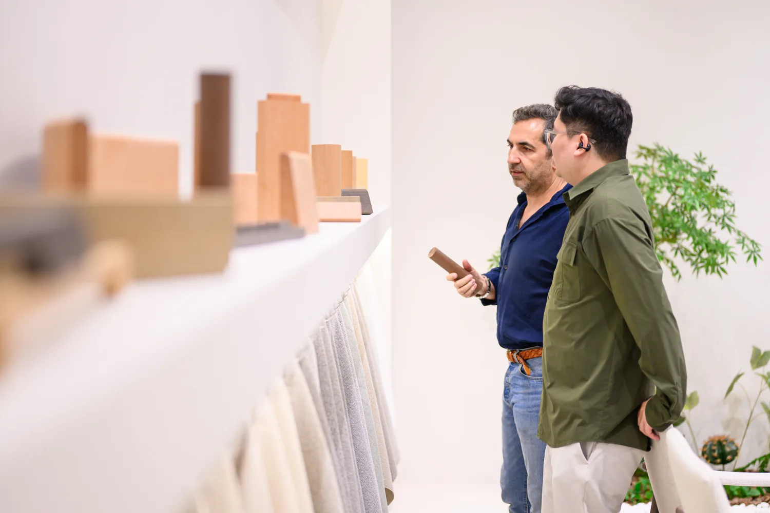 Two visitors examining a profile beside a material display