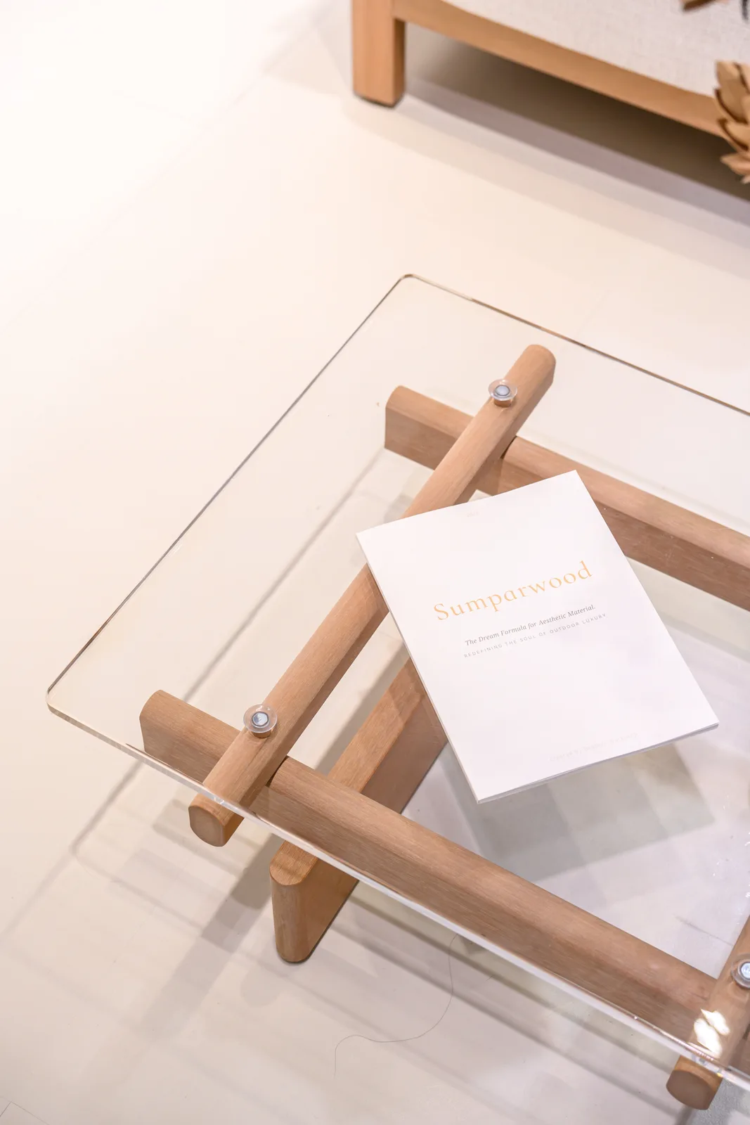 Sumparwood booklet on a transparent tabletop above crossed supports