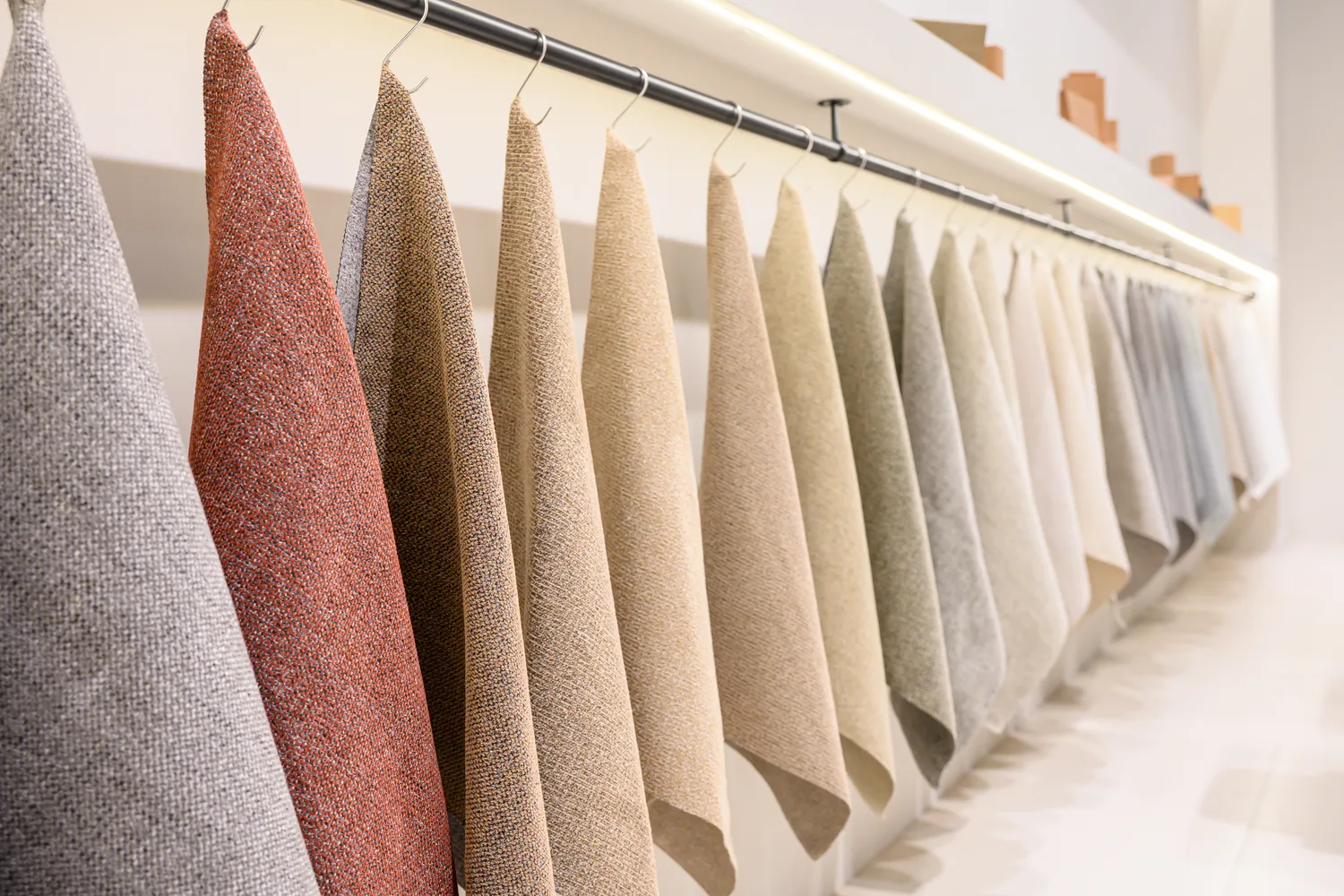 Red and neutral fabric swatches hanging below a material display