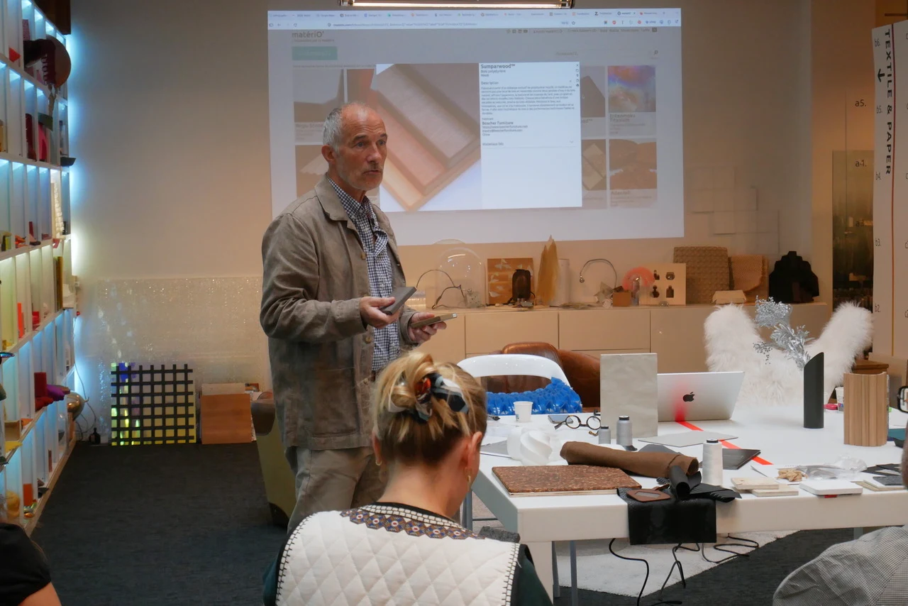 Presenter holding Sumparwood samples beside the projected material information card