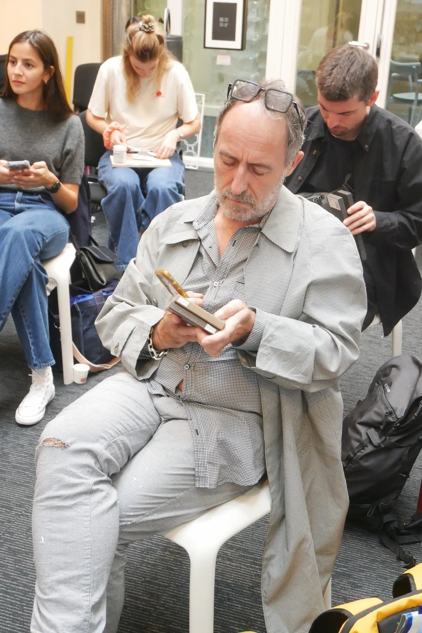 Seated participant examining the surface and edge of a rectangular material sample