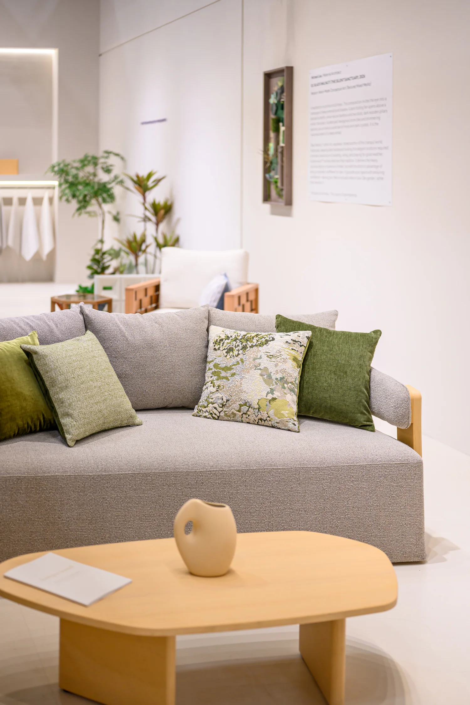 Grey sofa with green and patterned loose pillows at an exhibition