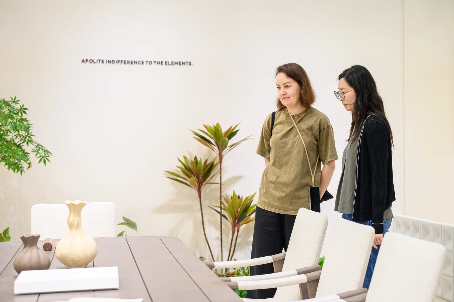 Two visitors looking at an exhibited dining table and chairs