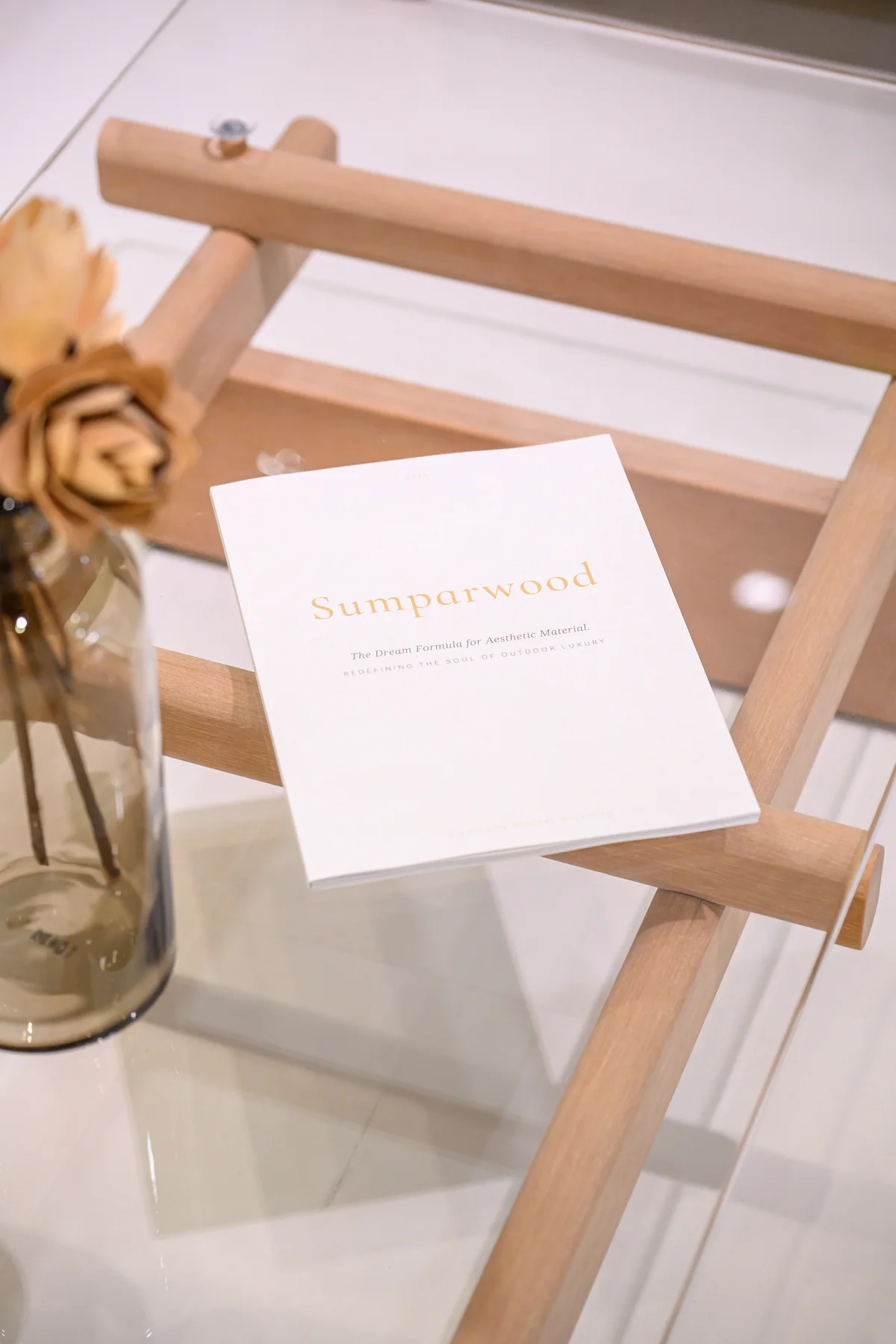 Glass-topped table with a crossing frame beside a printed information sheet