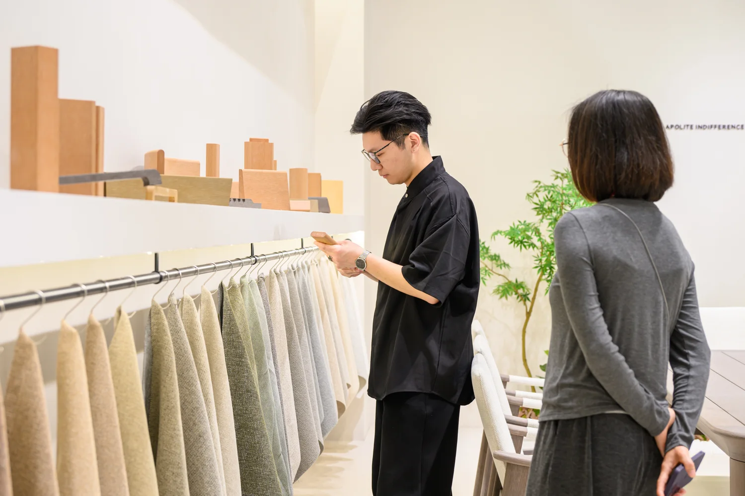 Two people reviewing fabric swatches beside material samples at an exhibition