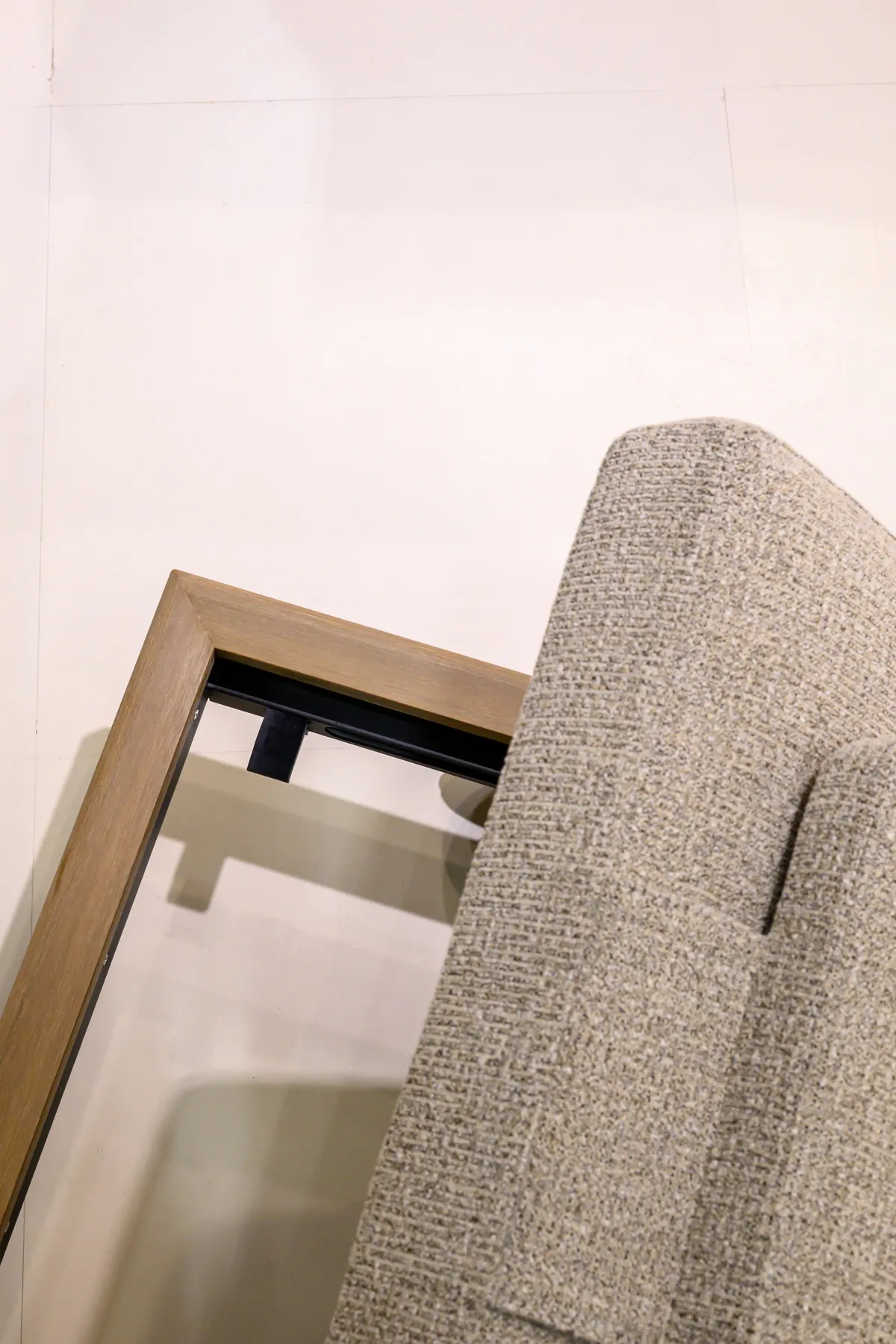 Close view of a tan armrest beside a black support and textured cushion
