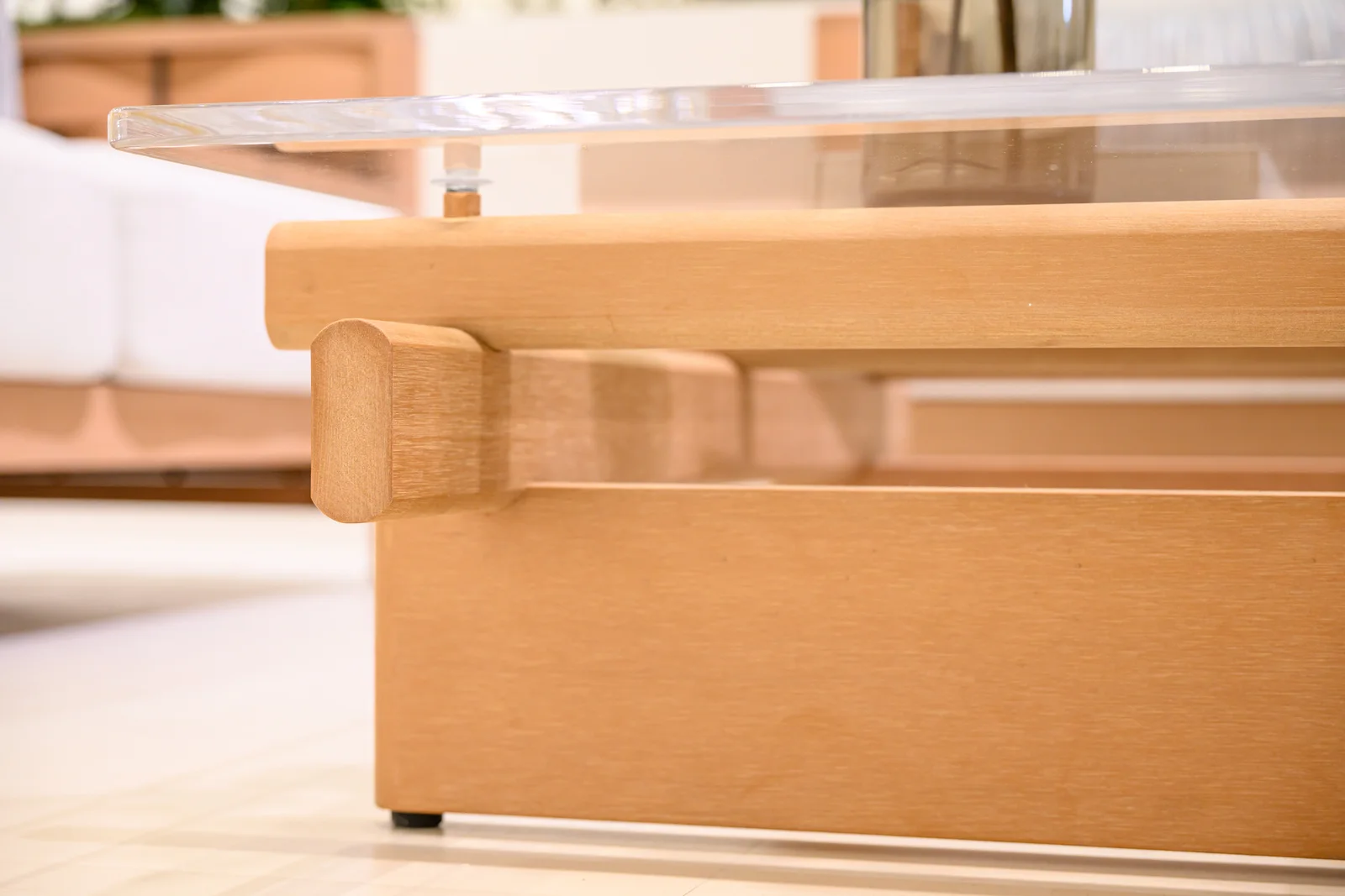 Low transparent tabletop resting above a broad warm-toned base