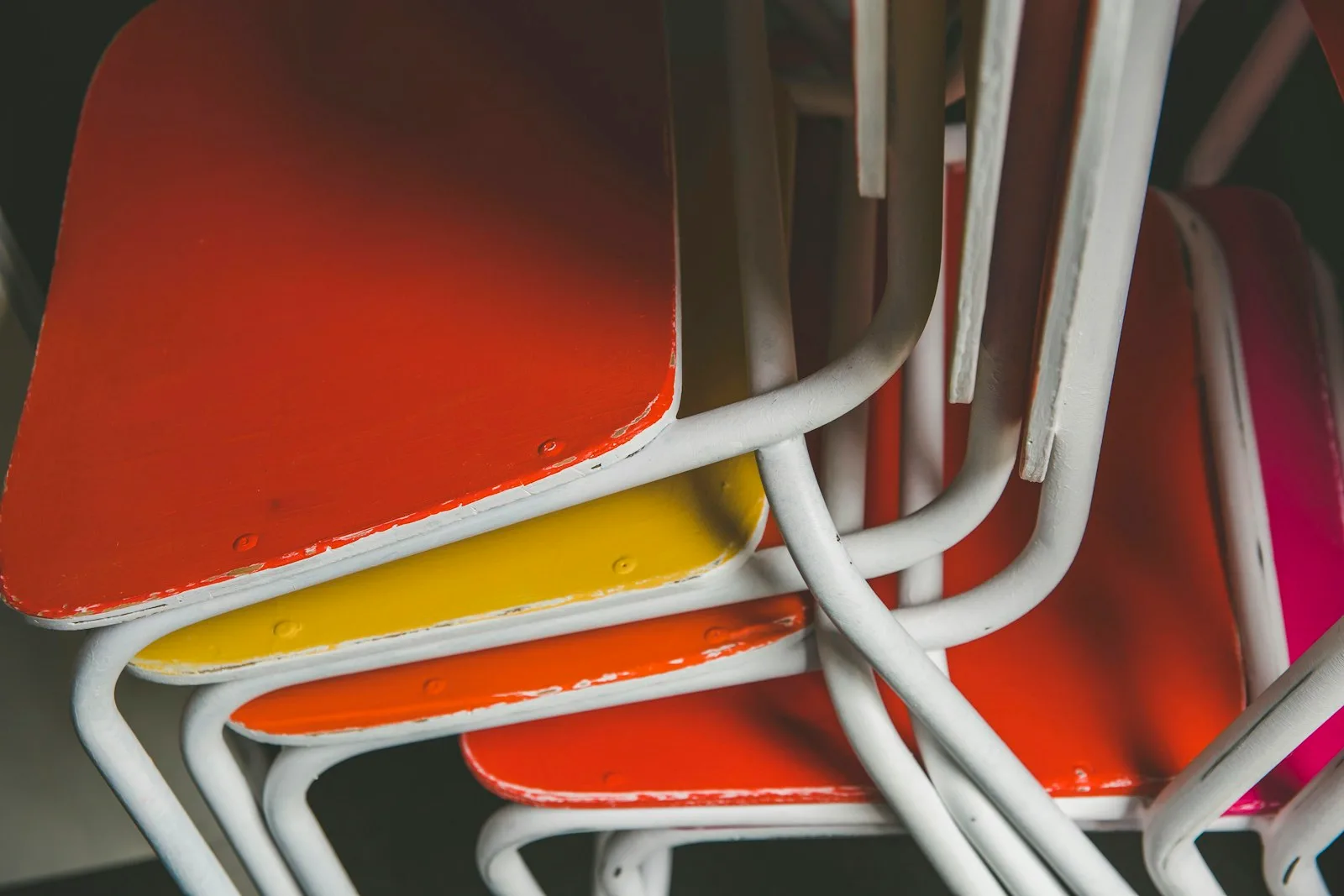 Red and yellow chairs nested together in a storage shed
