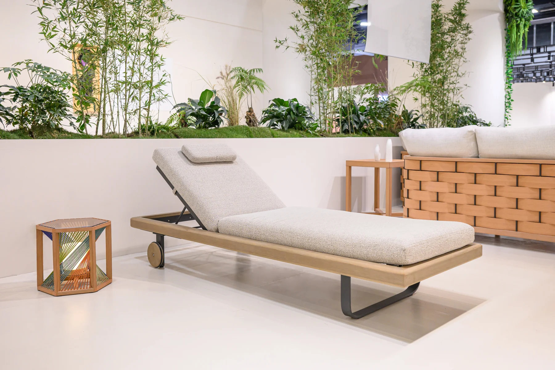 The lounger displayed with furniture and plants at an exhibition