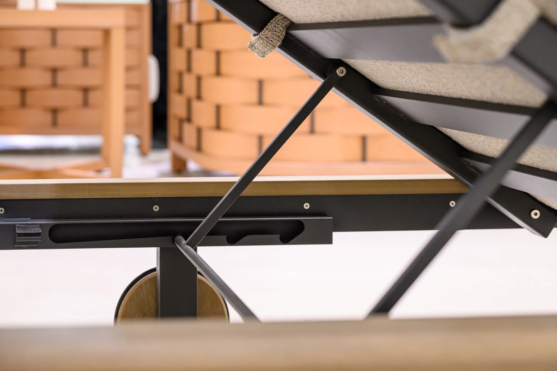 Close view of the lounger back support and slotted rail above a rear wheel