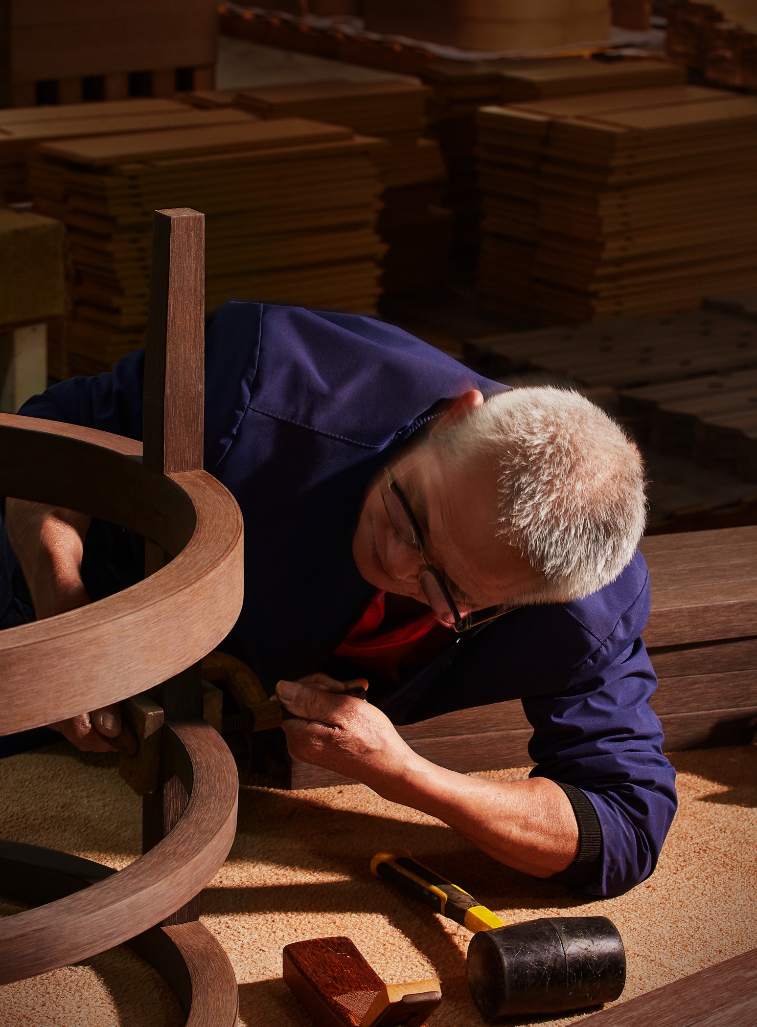 Boscher craftsman inspecting and hand-finishing a curved Sumparwood furniture frame